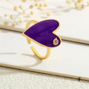 Close-up of golden heart ring with purple enamel and small crystal diamond detail
