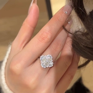 Close-up of a silver four-leaf clover ring with white pearls and sparkling zircons