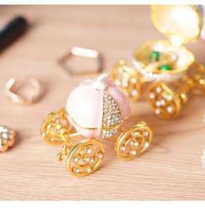 Detail of a pink and gold pumpkin carriage jewelry box with enamel finish and crystals