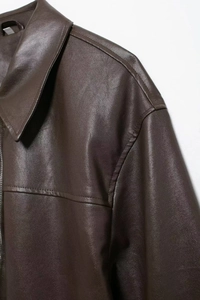Close-up of premium dark brown faux leather texture and collar stitching on aviator jacket