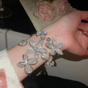 Detailed view of silver flower and butterfly bracelet with sparkling zircon stones