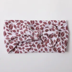 Detailed view of elastic nylon baby headband featuring a large American football print bow