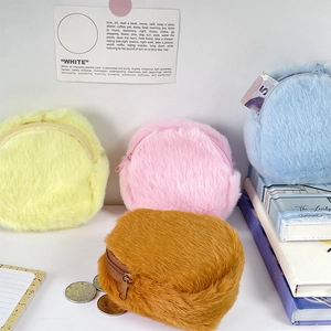 Close-up of four colorful plush coin purses with soft fur texture and zip closure