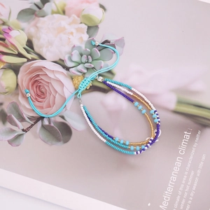 Bohemian multi-layer handmade beaded bracelet with blue and gold beads on flower magazine