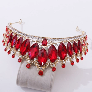 Detailed macro of Baroque gold crown featuring large marquise red rubies and white crystals