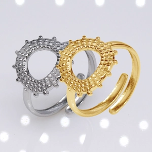 Detail of stacked gold and silver adjustable open rings with textured relief edges