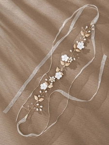Detail of bridal headband with ceramic flowers, gold leaves, pearls and crystal beads