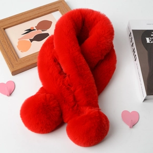 Detail of red faux fur scarf featuring soft plush pom-poms on a decorative background