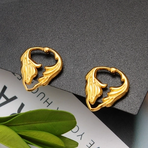 Detail of 18K gold butterfly wing earrings featuring elegant leaf textures on black background