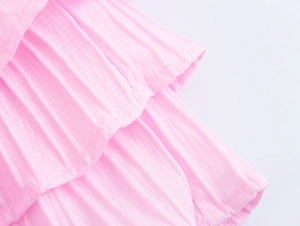 Close-up of pink layered ruffle tiered skirt showing pleated fabric texture and fine stitching