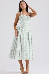 Detail of white halter neck floral dress with green print and delicate ruffles