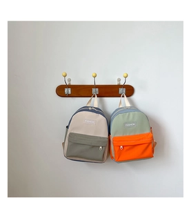 Minimalist canvas kids backpack hanging on wooden hooks in beige and green colorways