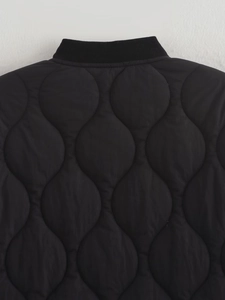 Detail of black quilted cotton jacket featuring ribbed collar and wave-patterned stitching