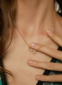 Detailed close-up of double interlocking rings necklace in gold finish with crystals