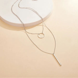 Detail of S925 sterling silver layered necklace with minimalist circle and vertical bar pendants