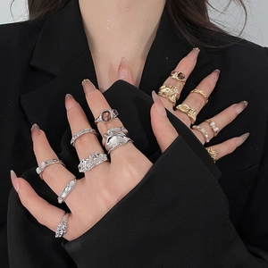 Detail of stacked ring set featuring lava texture and gemstone accents on a black backdrop