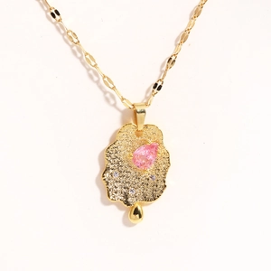 Detail of gold necklace featuring irregular cloud pendant with pink drop gemstone and tiny diamonds