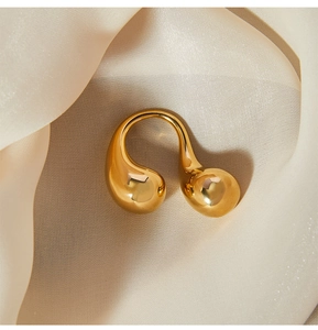 Macro detail of gold plated titanium steel ring with liquid teardrop and sphere design