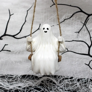 Detailed view of a cute white ghost figurine on a wooden swing for Halloween garden decor