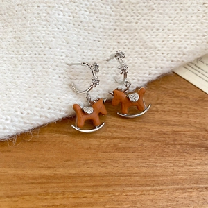Dettaglio di orecchini a forma di cavallo a dondolo in resina marrone e finiture argento