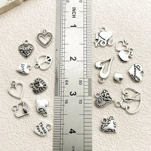 Vintage heart charms with love letters on scale ruler for jewelry making size guide