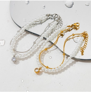 Gros plan des bracelets en perles à double couche avec pendentifs en zircon doré et argent