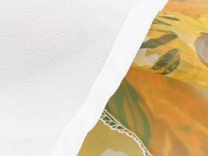 Macro view of sunflower print organza fabric and neat stitching on a tiered long skirt