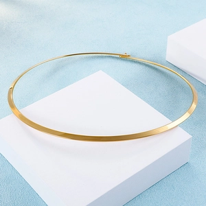 Macro shot of 4mm rigid gold titanium steel choker on a white geometric stand