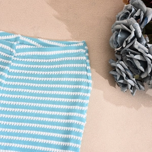 Detailed view of blue and white striped knit fabric with decorative blue roses