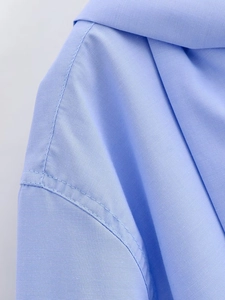 Detail of light blue shirt shoulder with double-stitching and twill fabric texture