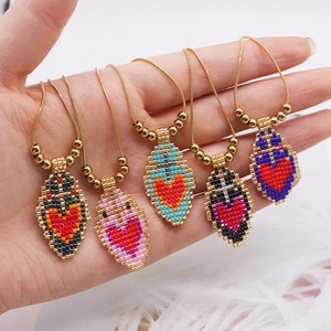 Detailed close-up of handmade miyuki heart pendants on adjustable stainless steel chains