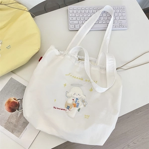 Close-up of white canvas tote bag with detailed lamb embroidery and drawstring closure