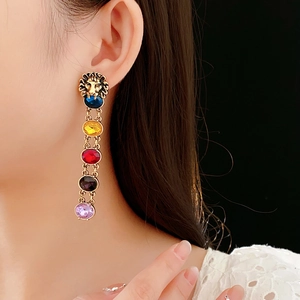 Gros plan d'une boucle d'oreille lion vintage avec pampilles en pierres colorées