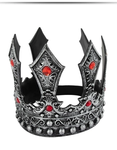 Close-up of vintage silver king crown with ornate embossing and red faux gemstones