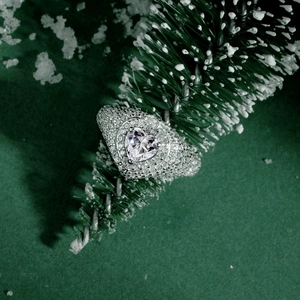 Macro detail of S925 silver heart ring with pavé zircons on festive pine branch