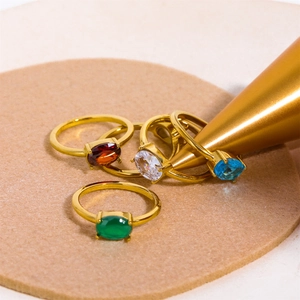 Macro shot of gold stainless steel rings with oval red, white, blue and green zircons