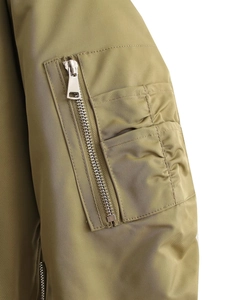 Macro detail of military green flight jacket sleeve with utility pocket and nylon texture