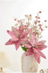Fleurs de poinsettia roses en velours avec paillettes dorées dans un vase en céramique