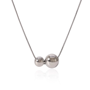 Détail des pendentifs sphériques en argent poli sur un collier avec chaîne serpent
