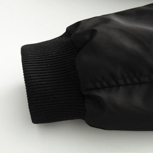Detailed macro view of black ribbed knit cuffs on an oversized bomber jacket sleeve