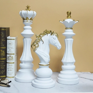 Three-piece set of white resin chess sculptures with gold accents including king queen and knight