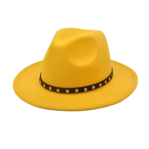 Detail of yellow wool fedora featuring a black leather band with silver metal rivets