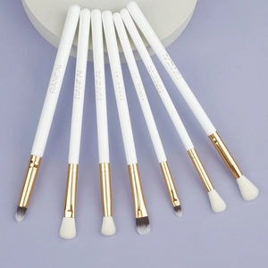 Detail of 7pcs professional eye makeup brush set with white handles and gold ferrules