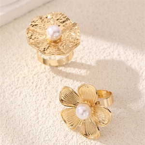 Detail of adjustable gold-plated flower and wave rings with central white pearls