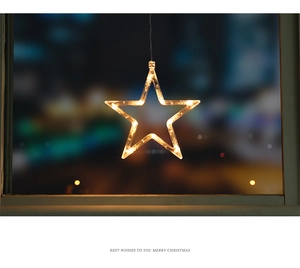 Macro view of warm LED star light hanging by window with festive bokeh background