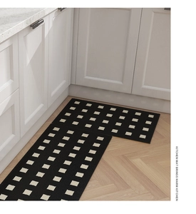 Detail of waterproof kitchen mat with white grid pattern on black non-slip texture