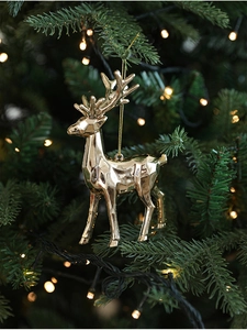 Decorazione a forma di renna dorata su albero di Natale con calde luci bokeh festive