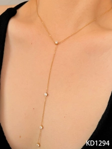 Detail of Y-shaped gold necklace with zircon pendants worn on model with elegant styling