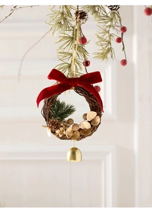 Nahaufnahme vom handgemachten Weihnachtskranz mit roter Samtschleife und Goldglocke