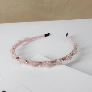 Macro detail of hand-stitched pink crystals and sparkling rhinestones on fabric headband
